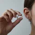 ręce wkładające kolczyk kółko